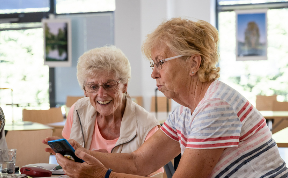 Zwei Seniorinnen betrachten ein Smartphone