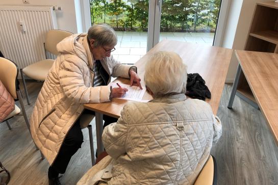 Zwei Seniorinnen schreiben am Tisch