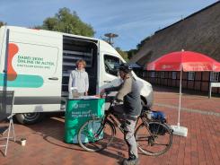 Ein Besucher steht auf seinem Fahrrad vor unserem Infomobil