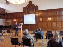 Die Teilnehmenden sitzen im Raum und schauen zur Präsentation an der Leinwand