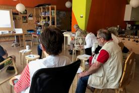 Senioren sitzen auf den Stühlen und hören einem Vortrag zu