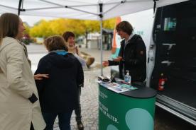 Besucherinnen stehen vor unserem Stand am Infomobil und unterhalten sich mit unserem Mobilreferenten Johannes Diller