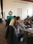 Drei Frauen sitzen am gedeckten Frühstückstisch, im Hintergrund ist der Stand vom Digitalen Engel.