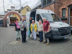 Mehrere Besucher:innen und Johannes stehen vor dem Infomobil 