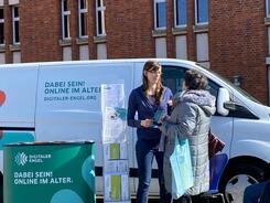 Petra ist an dem Info-Stand vor dem Info-Mobil mit einer älteren Dame im Gespräch.