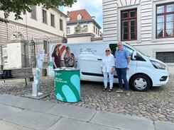 Petra (links) posiert mit drei Mitgliedern des Lüneburgers Seniorenbeirats vor dem Info-Mobil des Digitalen Engel am Info-Stand.