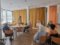 Mehrere Personen sitzen an Tischen verteilt im Raum und blicken zu Mobilreferent Johannes der in der Mitte steht.