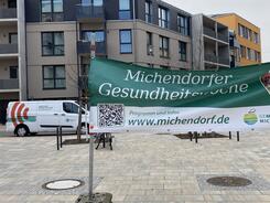 Rechts im Vordergrund ist ein Banner mit der &Uuml;berschrift "Michendorfer Gesundheitswochen" und der Internetadresse www.michendorf.de. Links im Hintergund steht das Info-Mobil des Digitalen Engel.