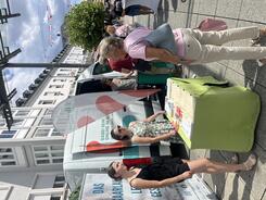 Mehrere Personen stehen vor einem Tisch und dem Infomobil