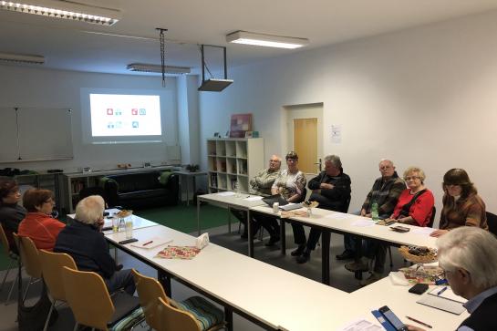 Senioren sitzen am Tisch und hören dem Vortrag des Digitalen Engels in Bernsdorf zu