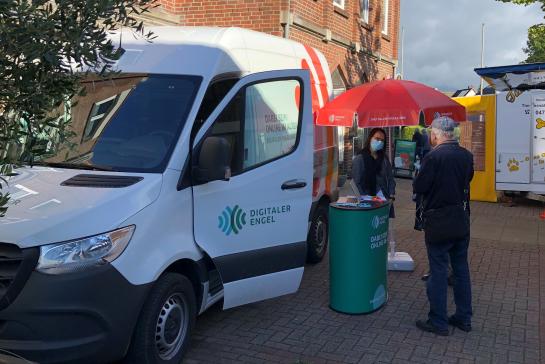 Zwei Personen sprechen mit Digitalen Engeln auf dem Marktplatz in Langen