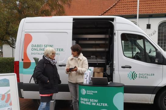 Eine Person spricht mit Digitalen Engeln auf dem Marktplatz in Heide