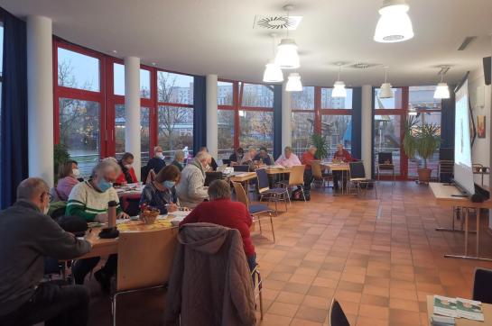 Senior:innen sitzen im Raum und schreiben