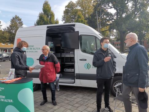 Zwei Besucher stehen vor dem Infomobil und unterhalten sich mit unserem Mobilreferenten und lokalem Ansprechpartner