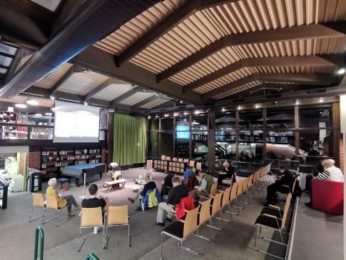 Die Teilnehmenden sitzen im Raum und schauen zur Präsentation auf der Leinwand