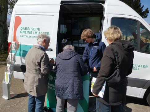 Besucherinnen stehen vor dem Infomobil und unterhalten sich mit unserem Referenten