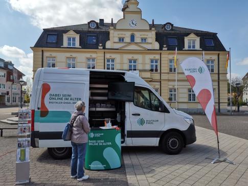 Eine Besucherin steht vor dem Infomobil und schaut auf unseren Infobildschirm