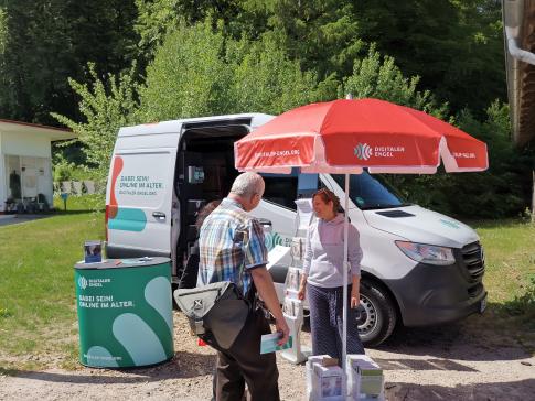 Besucher:innen stehen vor dem Infomobil und unterhalten sich mit unserer Projektleiterin Katharina Kunze 