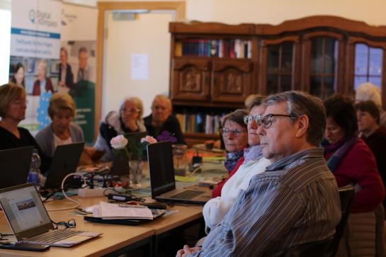 Die Teilnehmenden sitzen im Raum und schauen zur Präsentation an der Wand