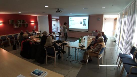 Gruppenfoto der Teilnehmenden, die zu unserem Referenten und zur Präsentation blicken