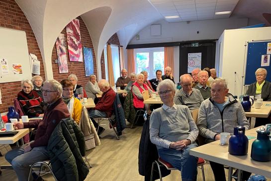 Die Teilnehmenden sitzen im Raum und schauen zur Präsentation an der Wand