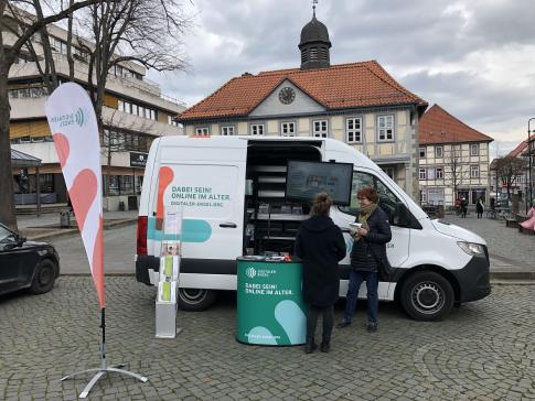 Eine Besucherin steht am Infomobil und unterhält sich mit Frau Marquis.