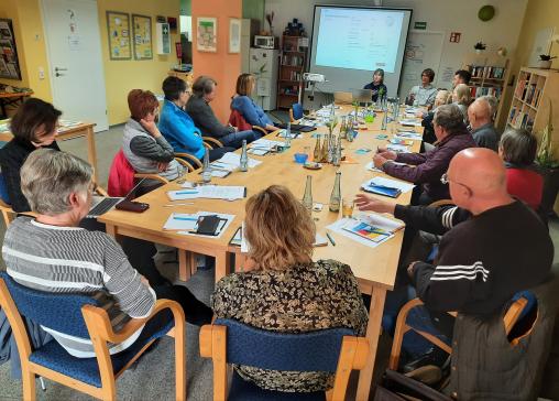 Die Teilnehmenden sitzen im Raum und schauen zur Präsentation an der Wand