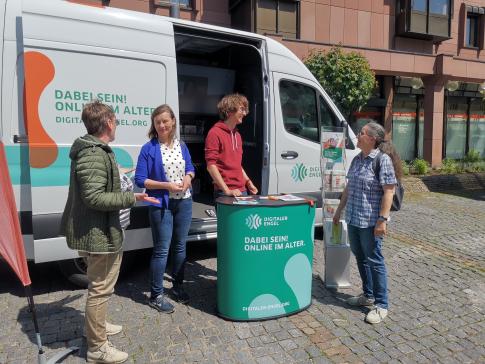 Besucherinnen stehen vor dem Infomobil und unterhalten sich mit unserem Referenten Johannes