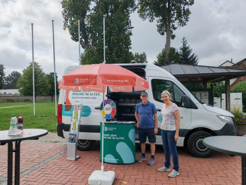 Frau Lutz von der Gemeinde steht mit einem Besucher vor dem Infomobil