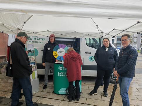 Besucher:innen stehen vor dem Infomobil und unterhalten sich mit unserem Referenten