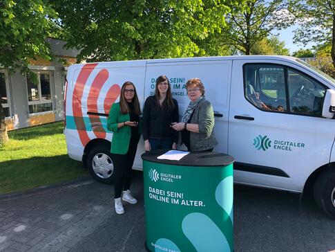 Petra (Mitte) steht mit Sandra Pragmann (links) und Gerlinde Wozniak (rechts) vor dem Info-Mobil, das neben dem Mehrgenerationenhaus Zeven geparkt ist.