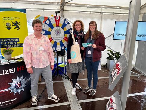 Petra (rechts) steht zusammen mit Elisabeth (mitte) und Frau Emde vom Polizeipräsidium Nordhessen (links) am Glücksrad. 