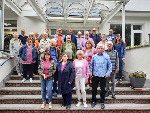 Ein Gruppenbild der rund 25 Teilnehmenden vor dem Gebäude der politischen Bildungsstätte Helmstedt. Die Senior:innen mit Petra (rechts) stehen auf einer Treppe.