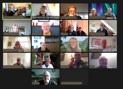 Ein Screenshot der Zoom-Veranstaltung. Auf 17 von 18 Kacheln sind die Teilnehmenden mit Kamera zugeschaltet. Die Kachel oben links zeigt das Internetcafé in Herne, von wo sich 10 Personen aus zugeschaltet haben. Auf zwei Kacheln sind jeweils zwei Personen zu sehen.