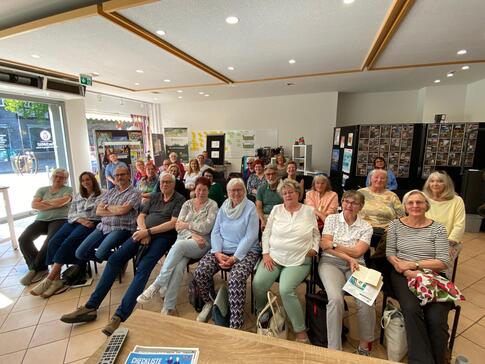 Rund 30 Senior:innen sitzen in drei langen Stuhlreihen im MitMachHaus in Goslar und blicken nach vorne in die Kamera.