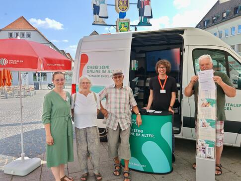 Mehrere Personen stehen vor dem Infomobil und blicken in die Kamera.