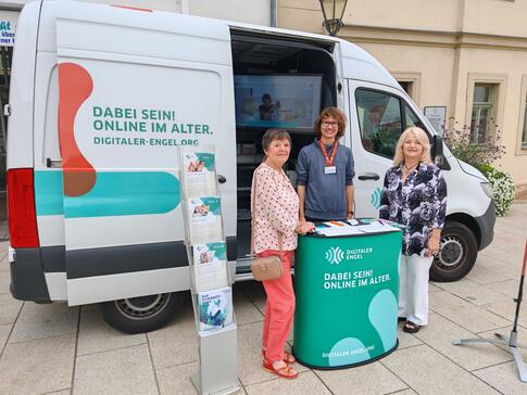 Mobilreferent Johannes steht mit zwei Damen vor dem Infomobil.