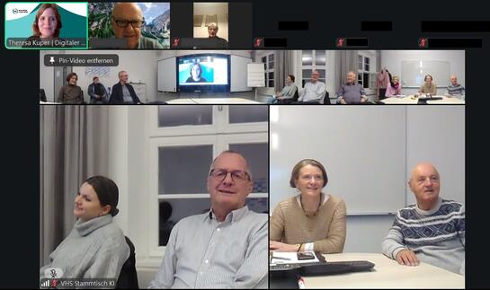 Der KI-Stammtisch aus Hof ist groß zu sehen. Über ihm sind die Video-Kacheln von Theresa und anderen Teilnehmenden abgebildet.