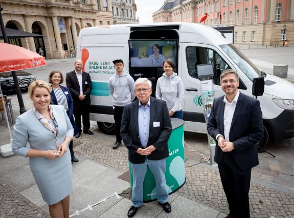 Personen mit Frau Giffey und dem Bürgermeistern von Potsdam vor dem Infomobil Auftaktveranstaltung