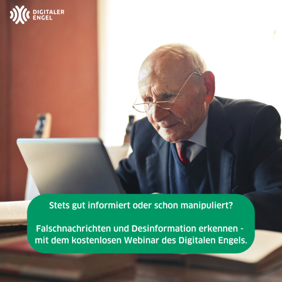 Älterer Mann sitzt am Schreibtisch und schaut auf einen Laptop.