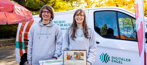 Junger Mann und junge Frau stehen vor einem Transporter